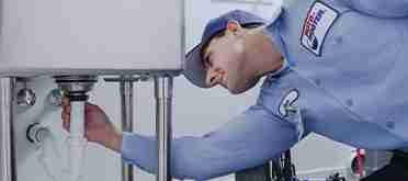 Plumbing technician inspecting drain pipe