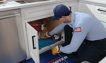 Plumber unclogging garbage disposal