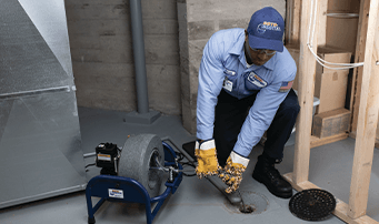 Technician cleaning sewer drain of residue