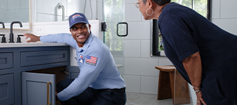 Roto-Rooter technician informing client on status of kitchen sink repair
