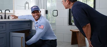 Roto-Rooter technician informing client on status of kitchen sink repair