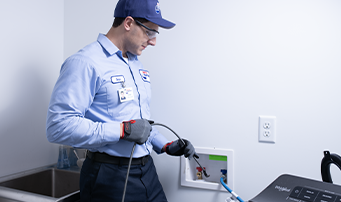 Roto-Rooter technician repairing washing machine